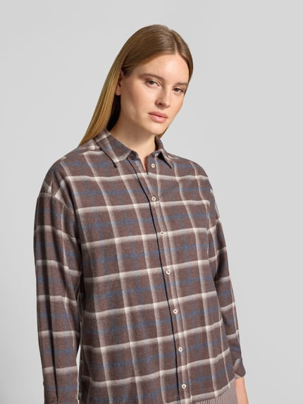 Frauenmodel trägt Relaxed Fit Hemdbluse in Layering-Optik von Emily Van den Bergh, Baumwoll-Mix, kariert, Knopfleiste, Nahaufnahme Oberkörper.