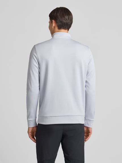 Männermodel trägt Sweatshirt mit Label-Detail van Under Armour, lichtgrijs, lange mouwen, geribde boorden, rugaanzicht, Ganzkörperansicht Rückansicht.