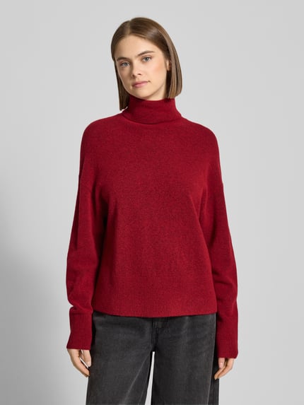 Frauenmodel trägt Regular Fit Rollkragenpullover aus Schurwoll-Mix von Marc O'Polo Denim in melierter Rotoptik, Stricktextur, Ganzkörperansicht von vorne.
