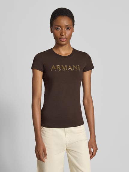 Frauenmodel trägt Slim Fit T-Shirt mit Label-Print von Armani Exchange in Dunkelbraun, Baumwoll-Elasthan-Mix, Rundhalsausschnitt, Ganzkörperansicht von vorne.
