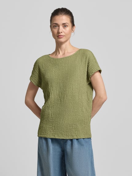 Frauenmodel trägt Relaxed Fit T-Shirt mit Strukturmuster von s.Oliver RED LABEL in Olivgrün, unifarben, kurzarm, Crinkle-Optik, Ganzkörperansicht von vorne.