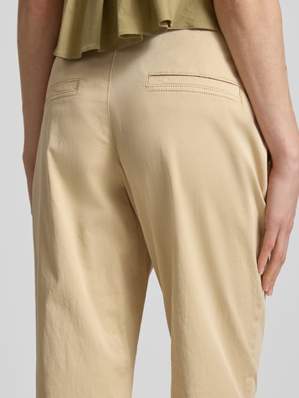 Vrouwenmodel draagt Regular Fit Chino uit katoenmix van s.Oliver RED LABEL, effen, mid waist, riemlussen, twillstructuur, detailopname rug.
