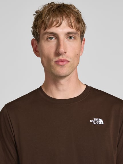 Mannenmodel draagt Regular Fit T-shirt met ronde hals Model 'EVOLUTION' van The North Face in bruin met labelstitching, Ruglengte bij maat M: 72 cm, Nahaufnahme Oberkörper.
