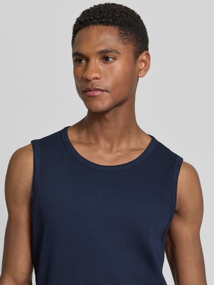 Männermodel trägt Slim Fit Tank Top aus Baumwoll-Mix von s.Oliver RED LABEL in Optik: Unifarben, Struktur: Feinripp, Nahaufnahme Oberkörper.