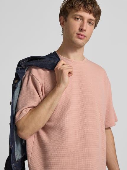 Männermodel trägt Herren T-Shirt mit Strukturmuster und Rundhalsausschnitt Modell 'PETER' von Redefined Rebel, Baumwoll-Mix, Relaxed-Fit, Ganzkörperansicht von vorne, Rückenlänge bei Größe M 70 cm.