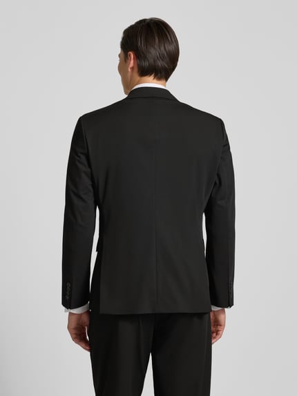 Männermodel trägt Regular Fit Anzugsakko mit Viskose-Anteil Modell 'LIAM' von SELECTED HOMME, unifarben, Rückenschlitz, Ganzkörperansicht Rückansicht.