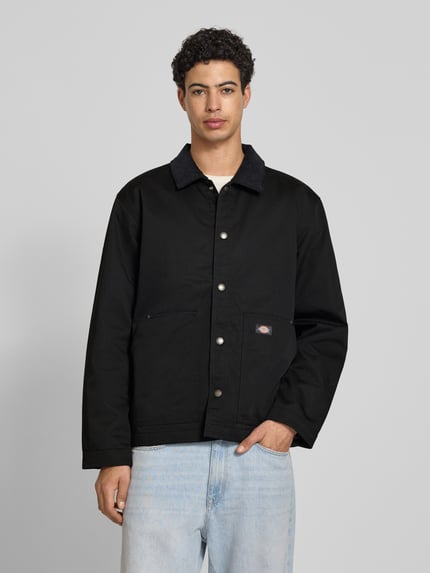 Männermodel trägt Jacke mit Umlegekragen und Label-Detail von Dickies in zwart met materiaalmix met katoen, regular fit, platte kraag, knoopsluiting, steekzakken, labeldetail, ruglengte maat M 75 cm, schouderbreedte 47 cm, borstwijdte 64 cm, mouwlengte 66 cm, geheel van voren te zien