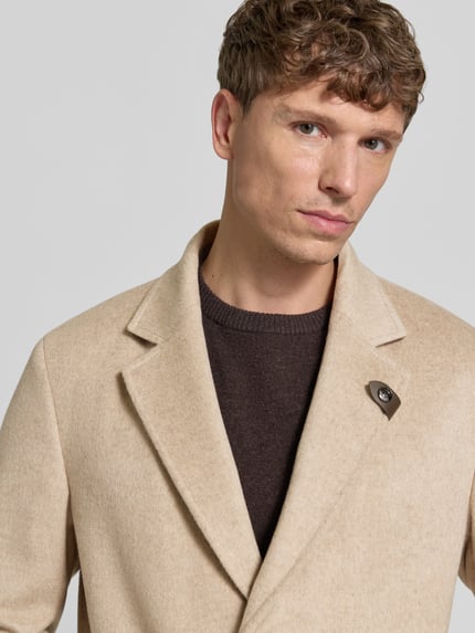 Männermodel trägt Regular Fit Mantel aus Woll-Mix Modell 'Morris' von JOOP! COLLECTION in Beige, brauner Pullover, Nahaufnahme Oberkörper.