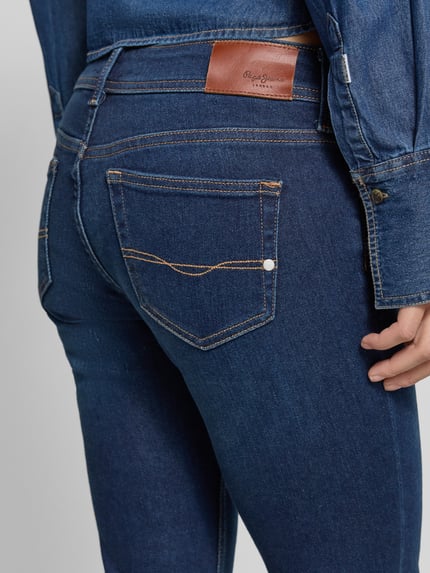 Frauenmodel trägt Slim Fit Bootcut Jeans aus Baumwoll-Mix Modell 'PIMLICO' von Pepe Jeans in Denim-Optik mit Label-Patch, Detailaufnahme
