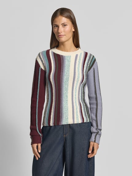 Kobieta nosi Regular Fit Pullover aus Viskose-Mix von Jake*s Collection, paski w odcieniach bordo, fioletu, kremu i niebieskiego, prosta faktura, Ganzkörperansicht von vorne.