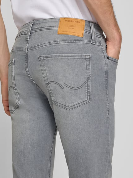Männermodel trägt Slim Fit Jeans aus Baumwoll-Mix Modell 'Glenn' von JACK & JONES, grauer Farbton, 5-Pocket-Design, Nahaufnahme Rückansicht. Kontext: Herren Jeans aus elastischem Baumwoll-Mix, Knopf- und Reißverschluss, Bundweite 41 cm, Innenbeinlänge 78 cm.