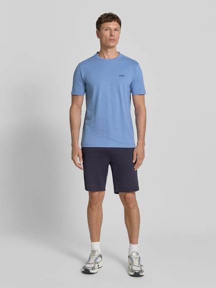 Männermodel trägt Regular Fit T-Shirt aus Baumwoll-Mix Modell 'TEE' von BOSS Green in Hellblau, Label Print, Ganzkörperansicht von vorne.