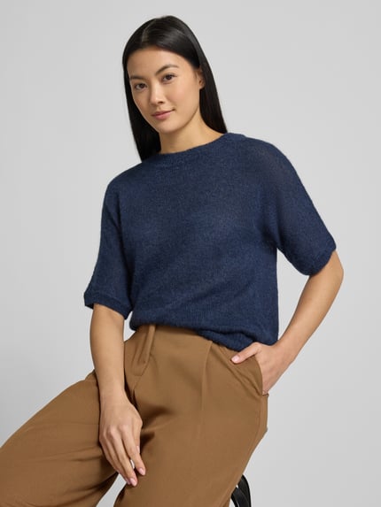 Vrouwenmodel draagt Regular Fit Strick-Shirt aus Alpaka-Mix Modell 'FANCER' van BOSS, unie kleur, korte mouw, geribde zoom, gebreide textuur. Nahaufnahme bovenlichaam.