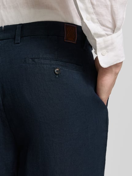 Männermodel trägt Leinenhose mit französischen steekzakken van g1920, zuiver linnen, straight fit, strookzak aan de achterkant, detailaufnahme rechterheup.