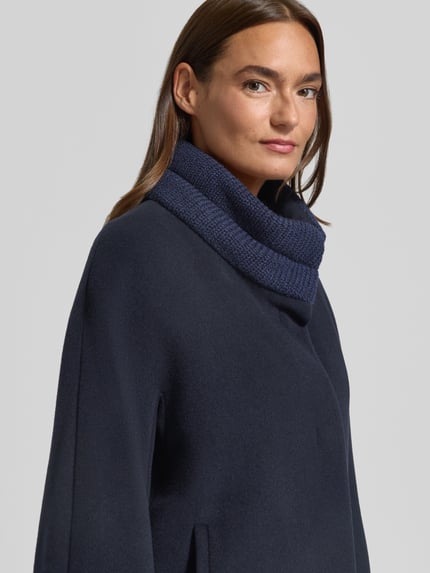 Frauenmodel trägt Jacke aus Lanawolle-Mix mit Stehkragen und Eingrifftaschen von ICONS Cinzia Rocca, dunkelblau, Nahaufnahme Oberkörper. Rückenlänge, Schulterbreite, Brustweite und Ärmellänge bei Größe 36, Relaxed Fit, feine Wolltextur, glatte Flächen.