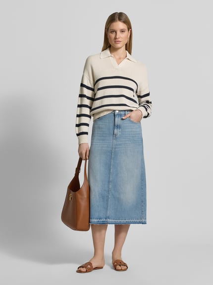 Vrouwenmodel draagt Ausgestellter Jeansrock aus reiner Baumwolle van Marc O'Polo in lichte denimkleur met open zoom, 5-pocket-design, label patch en riemlussen, midi-lengte, katoen, voorkant volledig zichtbaar, volledige lichaamsaanzicht van voren.
