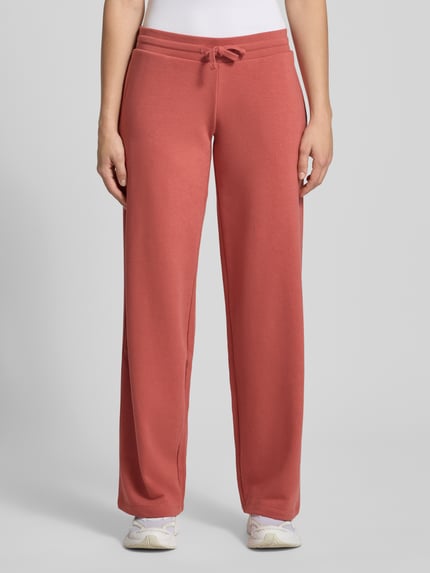 Frauenmodel trägt Sweatpants mit Tunnelzug von REVIEW in Koralle, Baumwoll-Mix, Gerader-Schnitt, Elastischer-Bund, Ganzkörperansicht von vorne.
