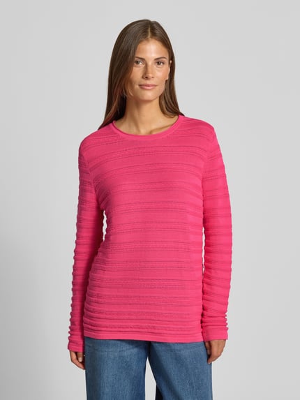 Frauenmodel trägt Regular Fit Pullover aus reiner Baumwolle in Strick-Optik von Christian Berg Woman in Pink mit Rundhalsausschnitt, semitransparent, Ganzkörperansicht von vorne.