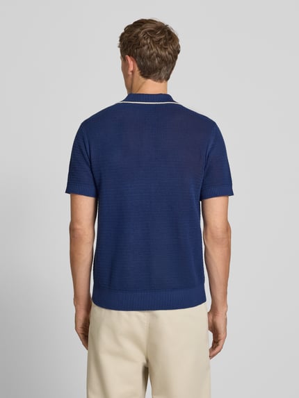 Männermodel trägt Regular Fit Poloshirt aus reiner Baumwolle Modell 'JESSE' von Selected Homme in Dunkelblau, Ganzkörperansicht Rückansicht. Herren Poloshirt von Selected Homme.