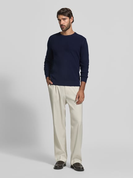 Męski model nosi Pullover aus Woll-Kaschmir-Mix Modell 'Rick' od BRAX, kolor melanżowy, dzianinowa faktura, okrągły dekolt, długi rękaw, ściągacze na rękawach i dole, materiał: mieszanka wełny i kaszmiru, pełny widok z przodu