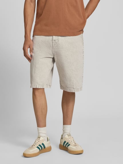 Männermodel trägt Jeansshorts mit Eingrifftaschen Modell 'Smithfield' von Carhartt Work In Progress in heller Waschung, Reine Baumwolle, Relaxed-Fit, Ganzkörperansicht von vorne. Bundweite bei Größe 32: 45 cm, Innenbeinlänge 28 cm.