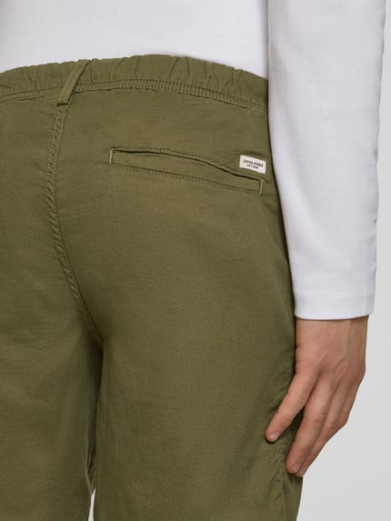 Männermodel trägt Shorts mit Tunnelzug Modell 'JAIDEN' von Jack & Jones aus Baumwoll-Leinen-Mix in Khaki, Regular-Fit, Detailaufnahme Rückansicht.