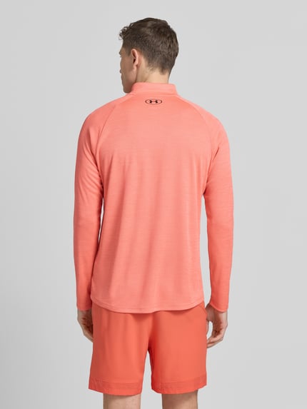 Männermodel trägt Sweatshirt mit kurzem Reißverschluss und Logo-Print von Under Armour, koralowy kolor, prosty krój, Stehkragen, Ganzkörperansicht Rückansicht