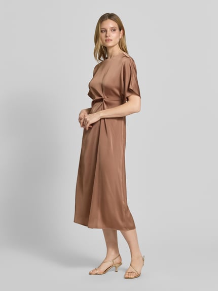 Vrouwenmodel draagt midi-jurk met knoopdetail model 'Dela' van JOOP!, satijn, recht model, ronde hals, Ganzkörperansicht van voren.