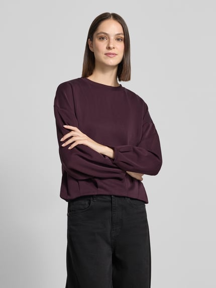 Vrouwenmodel draagt Oversized sweatshirt met viscose van comma, elastische materiaalmix, donkerpaars, geplooide schouders, lange mouwen, oversized fit, voorkant bovenlichaam close-up.