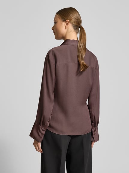 Frauenmodel trägt Hemdbluse mit Schnürverschluss von Mango in Braun mit Hemdblusenkragen, Wickel-Optik, Lockerer-Schnitt, Rückenlänge 62 cm, Ärmellänge 59 cm, Ganzkörperansicht Rückansicht.