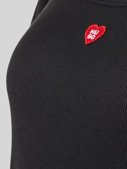 Frauenmodel trägt schwarzes Regular Fit Pyjama-T-Shirt aus Modal-Mix Modell 'HUGO HEART' von HUGO, feine Rippenstruktur, Nahaufnahme Oberkörper, Damen Pyjama von HUGO.