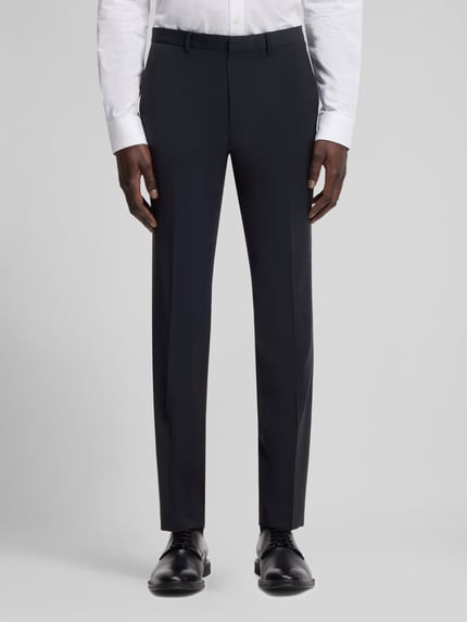 Męski model nosi Slim Fit Anzughose aus Woll-Mix Modell 'HESTEN' od HUGO, kolor melanżowy, gładki, krój slim fit, szlufki na pasek, kanty, kieszenie, szerokość w rozmiarze 50: 45 cm, długość nogawki: 79,5 cm, materiał: mieszanka wełny. Zdjęcie całej sylwetki z przodu.