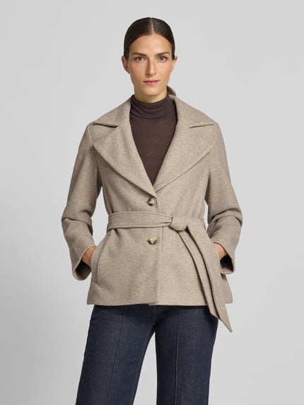 Frauenmodel trägt Regular Fit Webpelzmantel mit Bindegürtel Modell 'FORTUNEMAJA' von VERO MODA, beige, glatte Textur, Ganzkörperansicht von vorne, Damen Teddy- / Webpelzmantel.