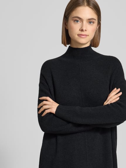 Frauenmodel trägt Oversized Strickkleid aus Schurwoll-Mix von Marc O'Polo Denim, unifarben, hochgeschlossen, Nahaufnahme Oberkörper.