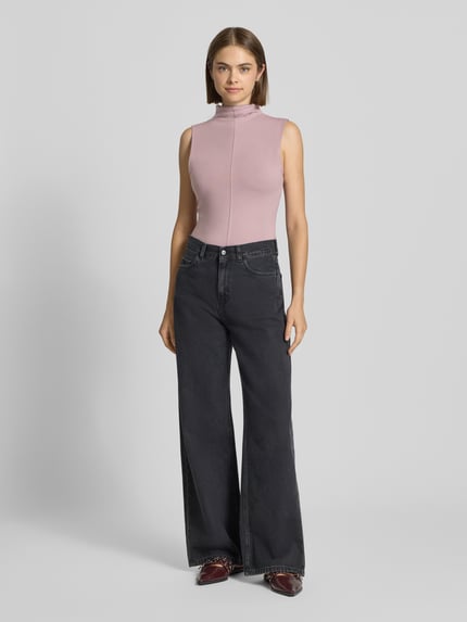 Frauenmodel trägt Slim Fit Top aus Baumwoll-Mix Modell 'Belisa' von Topshop in Rosa, kombiniert mit weiter schwarzer Hose, Ganzkörperansicht von vorne. Rückenlänge bei Größe S: 56 cm, elastisches Material, Stehkragen.