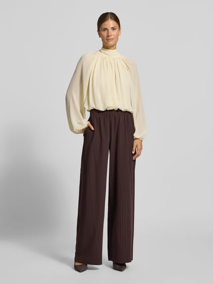Vrouwenmodel draagt Regular Fit Hose mit elastischem Bund van YAS, wijde broek in matte naaldstrepenlook met elastische tailleband en gerimpelde boord, geheellichaamsaanzicht van voren.