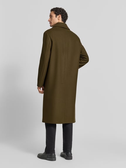 Männermodel trägt Regular Fit Mantel mit Eingrifftaschen von bugatti in Olivgrün, glatte Textur, Rückenansicht, Ganzkörperansicht Rückansicht. Schurwoll-Mix mit Kaschmir-Anteil, Umlegekragen, Knopfleiste, Rückenlänge 120 cm, Schulterbreite 47 cm, Brustweite 61 cm, Ärmellänge 67 cm.