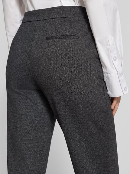 Frauenmodel trägt Hose aus Viskose-Mix Modell 'CHARLIE' von GUIDO MARIA KRETSCHMER WOMAN, dunkle Farbe, Paspeltasche, Nahaufnahme Rückansicht.