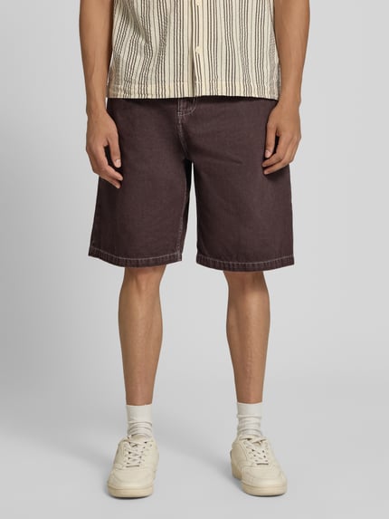 Männermodel draagt korte jeans Jeansshorts mit Eingrifftaschen Modell 'Clark' van Carhartt Work In Progress, puur katoen, relaxed fit, bandwijdte maat M 45 cm, binnenbeenlengte 26 cm, ganzkörperansicht van voren.