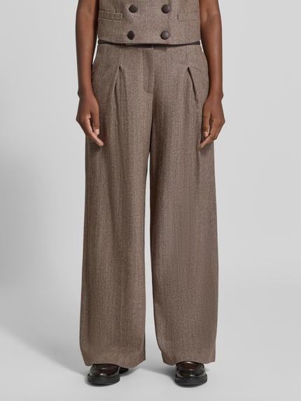 Kobiece modelka nosi spodnie z szerokimi nogawkami Wide Leg Hose aus Schurwoll-Mix mit Eingrifftaschen od Armani Exchange, mieszanka żywej wełny i jedwabiu, krój wide leg, zapięcie na guzik, wpuszczane kieszenie, szerokość w rozmiarze 36: 36 cm, długość wewnętrzna nogawki w rozmiarze 36: 83 cm, ujęcie z przodu, detal dolnej części ciała.