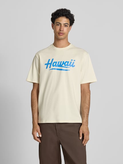Männermodel trägt Relaxed Fit T-Shirt aus reiner Baumwolle Modell 'RICO' von Only & Sons, unifarbenes Jersey mit blauem Motiv-Print, Rundhals, Kurzarm, Ganzkörperansicht von vorne.