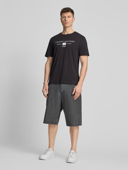 Männermodel trägt Regular Fit T-Shirt aus reiner Baumwolle von Tommy Hilfiger, Optik: Unifarben, Label-Print, Rundhals, Kurzarm, Ganzkörperansicht von vorne.