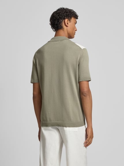 Männermodel trägt Regular Fit Freizeithemd mit Kentkragen Modell 'Galvo' von JOOP! Collection aus reiner Baumwolle, Ganzkörperansicht Rückansicht. Rückenlänge bei Größe M 68 cm, Schulterbreite 46 cm, Ärmellänge 26 cm, Hemd in Oliv mit glatter Textur.