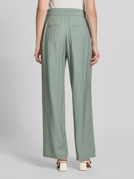 Frauenmodel trägt Wide Fit Chino aus Viskose-Mix mit Gesäßtaschen von Betty Barclay in zartem Grün, strukturierte Oberfläche, Ganzkörperansicht Rückansicht. Bundweite bei Größe 36: 36 cm, Innenbeinlänge: 80 cm, Haken- und Reißverschluss.
