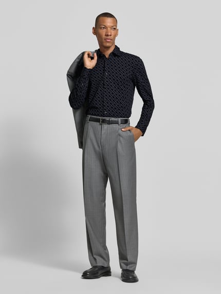 Männermodel trägt zwart slim fit zakelijk overhemd met kentkraag van BOSS, grijze broek, Ganzkörperansicht von vorne