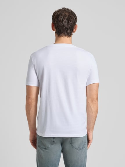 Męski model nosi Regular Fit T-Shirt aus reiner Baumwolle von Tom Tailor Denim, biały, krój regular fit, gładka struktura, widok całej sylwetki z tyłu.
