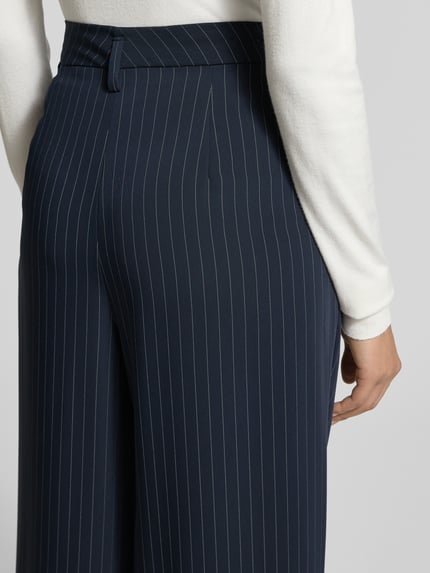 Frauenmodel trägt Stoffhose mit französischen Eingrifftaschen Modell 'MAYLA' von Raffaello Rossi, dunkelblauer Material-Mix mit Viskose-Anteil, lockerer Schnitt, Detailaufnahme Rückansicht.