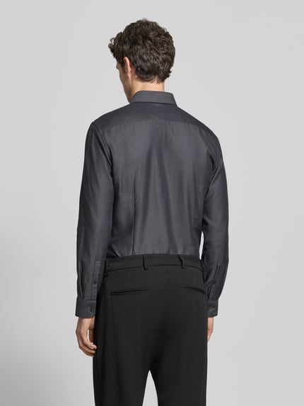 Männermodel trägt Slim Fit Businesshemd aus reiner Baumwolle von Jake*s in Unifarbe mit Kentkragen, Ganzkörperansicht Rückansicht.