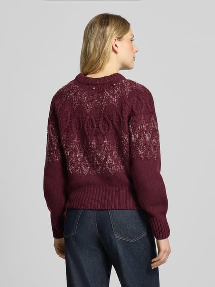 Frauenmodel trägt Pullover mit Zopfmuster Modell 'C_Fyrata' von BOSS Orange in Dunkelrot mit Struktur und Rundhalsausschnitt, Rückansicht.