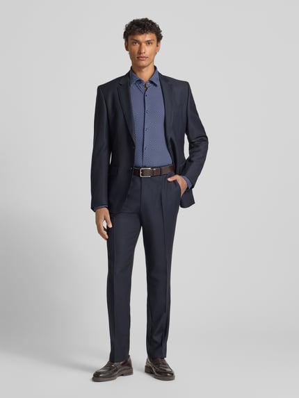 Männermodel trägt Slim Fit Businesshemd mit Kentkragen Modell 'KENNO' von HUGO, Optik: Unifarben, Allover-Muster, Ganzkörperansicht von vorne.